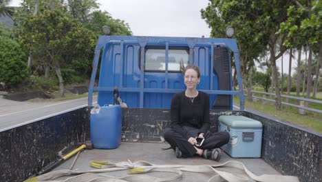 una joven autoestopista haciendo un viaje en la parte trasera de una camioneta en taiwán