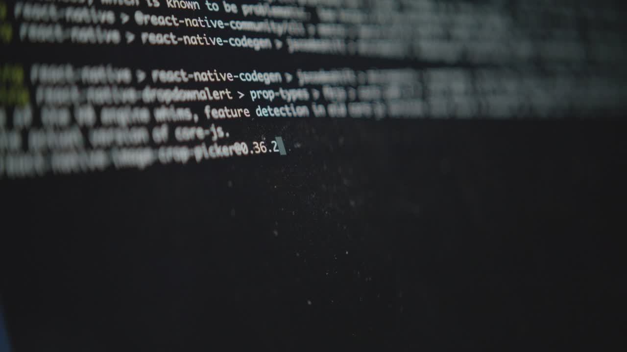 A close-up shot of a computer's command line interface. A blinking cursor and running text show a system process or script executing. Concept of hacking or software development