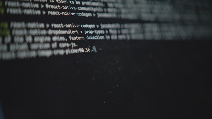 Et nærbillede af en computers kommandolinjegrænseflade. En blinkende markør og løbende tekst viser en systemproces eller et script, der udføres. Koncept for hacking eller softwareudvikling.