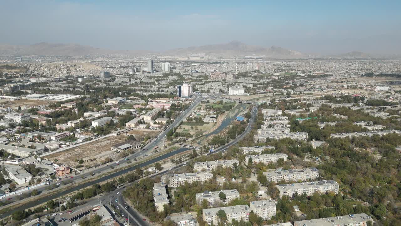 Drone Aerial of Kabul Afghanistan, Busy Traffic in city center, Hindu Kush mountains in background
