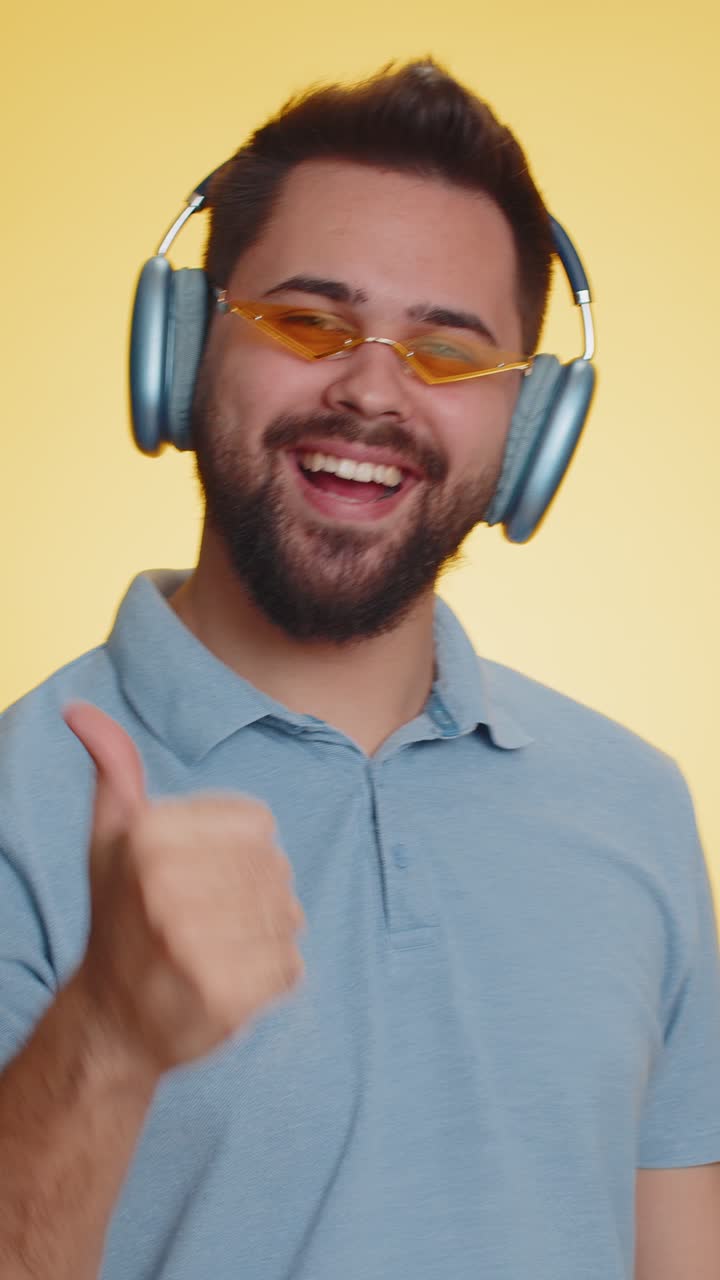 Giovane vincitore felice uomo che ascolta musica con le cuffie che balla la discoteca che si prende gioco di festeggiare