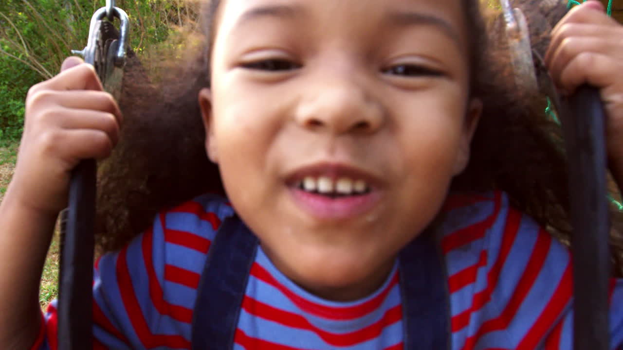 dos niñas jugando al aire libre en casa en columpios de jardín
