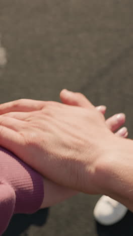 primer plano de la mano extendida con otras personas en el fondo colocando sus manos juntas como equipo en una actividad deportiva, mostrando unidad, colaboración y trabajo en equipo en un entorno al aire libre