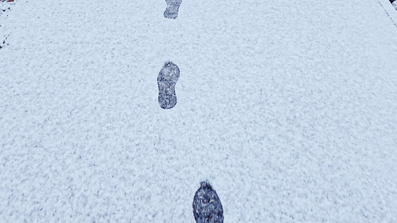 Orme sulla neve conducono in avanti su un sentiero bianco: movimento invernale nella città di Riga
