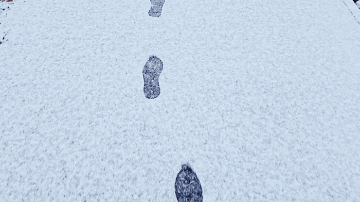 Orme sulla neve conducono in avanti su un sentiero bianco: movimento invernale nella città di Riga