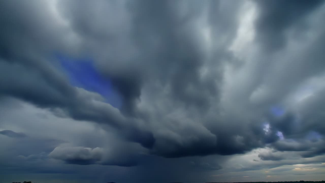 Complejo de nubes de tormenta que avanza y se intensifica sobre una amplia llanura, mostrando un frente de lluvia central y brillo