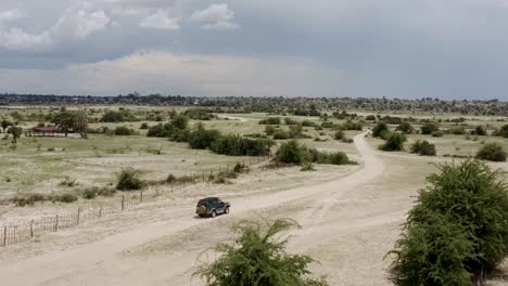 Aerial:-Safari-Jeep-Game-Driving-Tourists-On-Sunny-Morning-In-African-Savanna