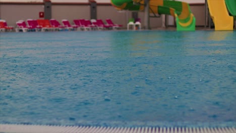 aguas azules reflectantes de una piscina pública durante un período de fuertes lluvias