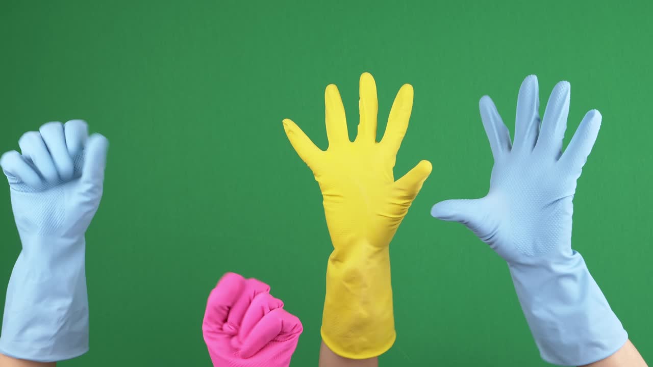 보호용 고무 장갑을 쓴 많은 손들이 녹색 크로마키 배경에서 손가락을 즐겁게 고 풀고 있습니다.