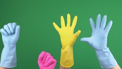 muchas manos con guantes de goma protectores con alegría apretando y soltando sus dedos sobre el fondo verde chromakey. video 4k