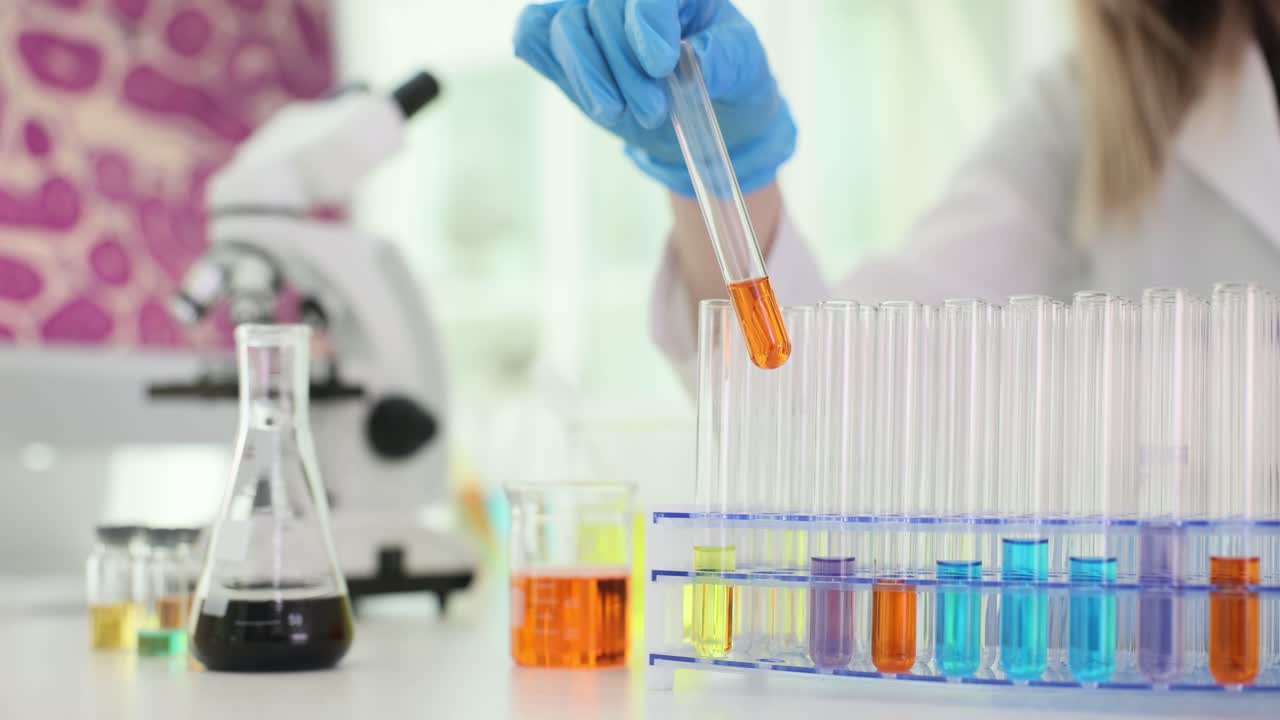 Scientist working with colorful liquid samples in test tubes in a laboratory