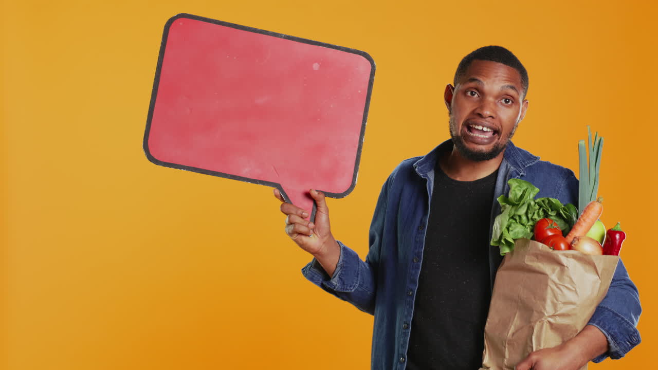Young man showing a speech bubble empty cardboard sign to create an ad