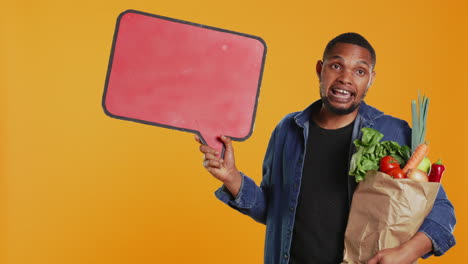 young man showing a speech bubble empty cardboard sign to create an ad