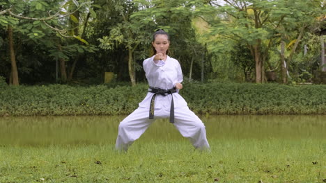 una mujer joven practicando taekwondo.