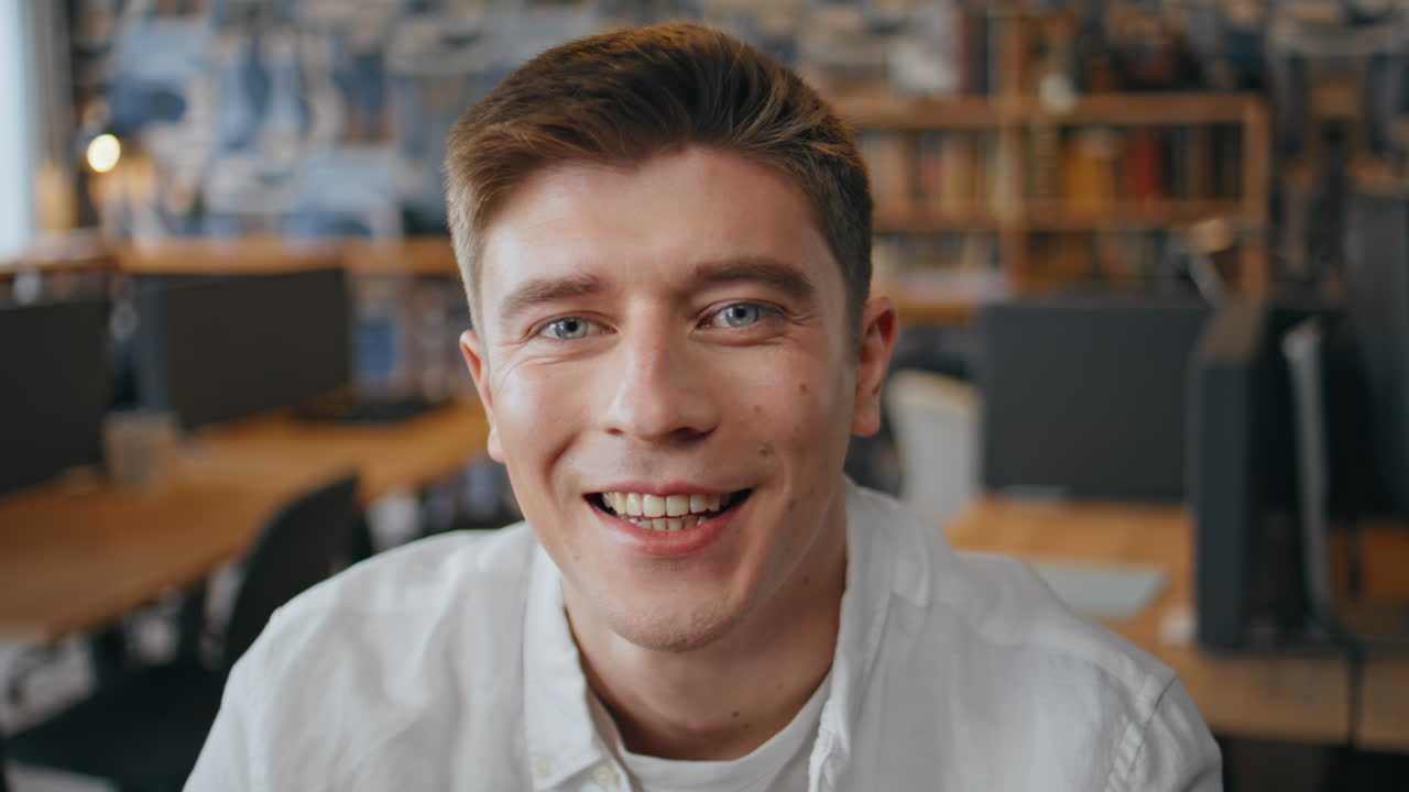 Portrait successful executive posing at office desk. Smiling man looking camera