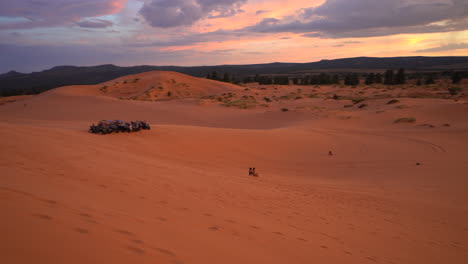 Dos-Personas-Practicando-Sandboard-En-Las-Dunas-De-Arena-Rosa-Durante-La-Puesta-De-Sol