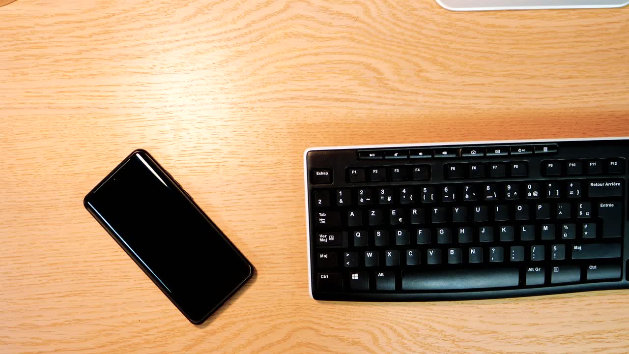 Smartphone and Keyboard on Wooden Desk