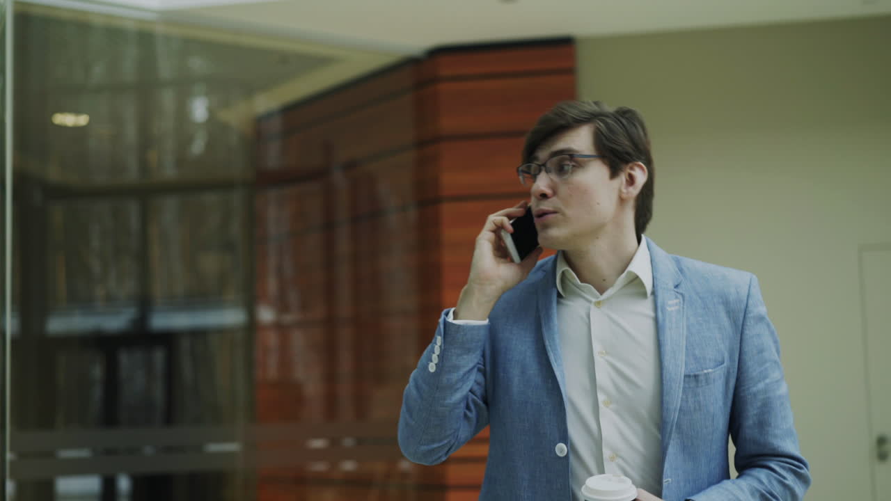 Businessman Talking on Phone in Office Building