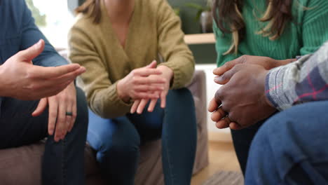 diverse group of friends holding hands in group therapy session