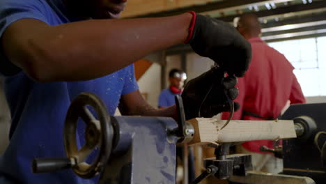 african american instructor mounting blank on lathe, guiding apprentice shaping wood in workshop