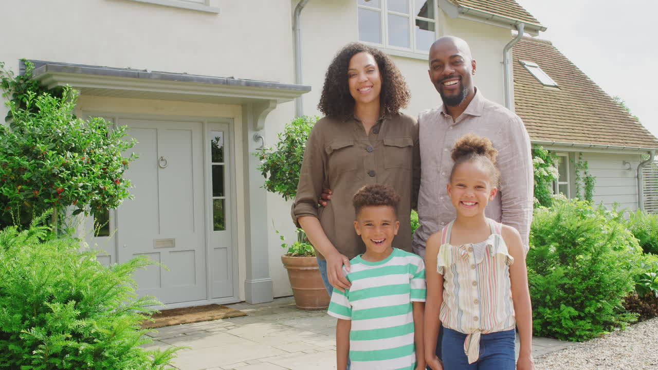 Portret van een glimlachend gezin dat samen buiten het huis staat
