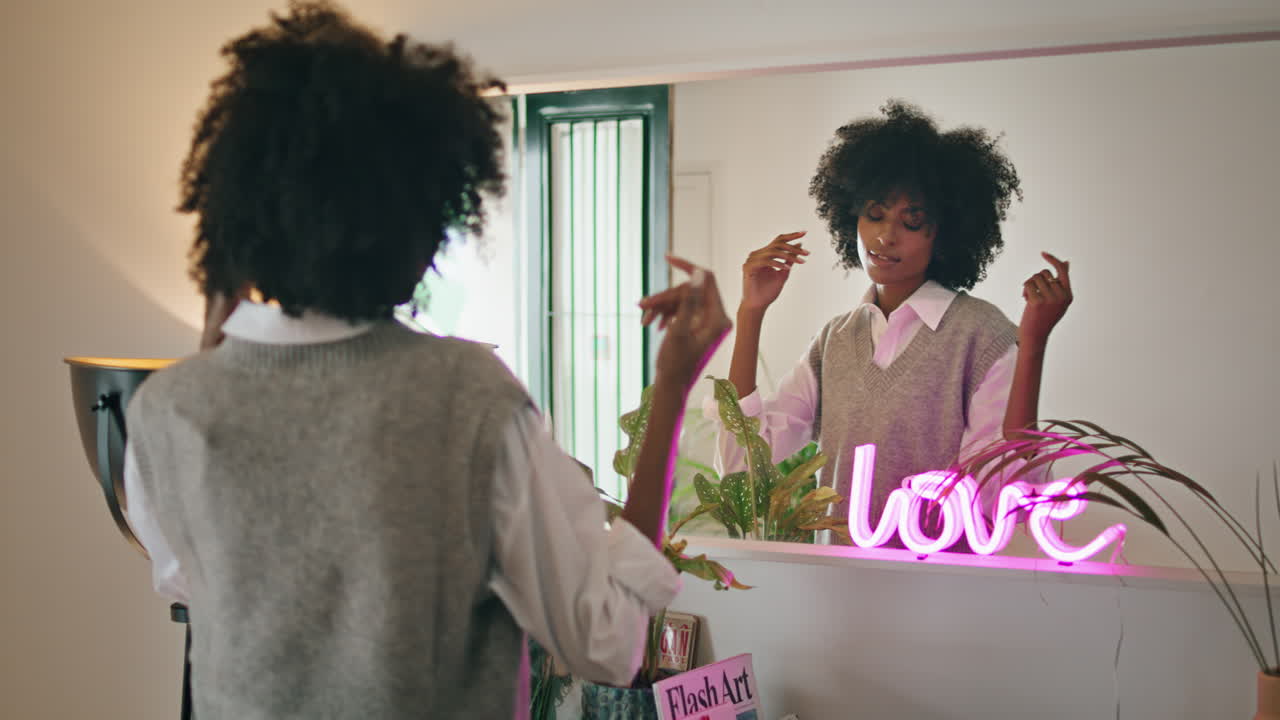 Young woman dancing mirror close up. African american girl admiring reflection.