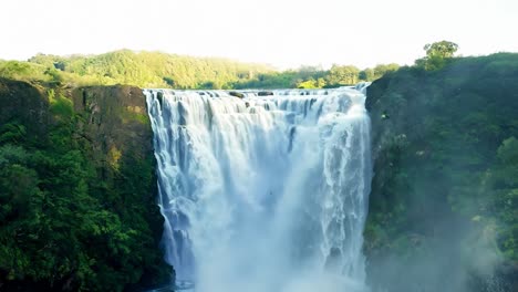 stunning view of a large waterfall in a lush green forest