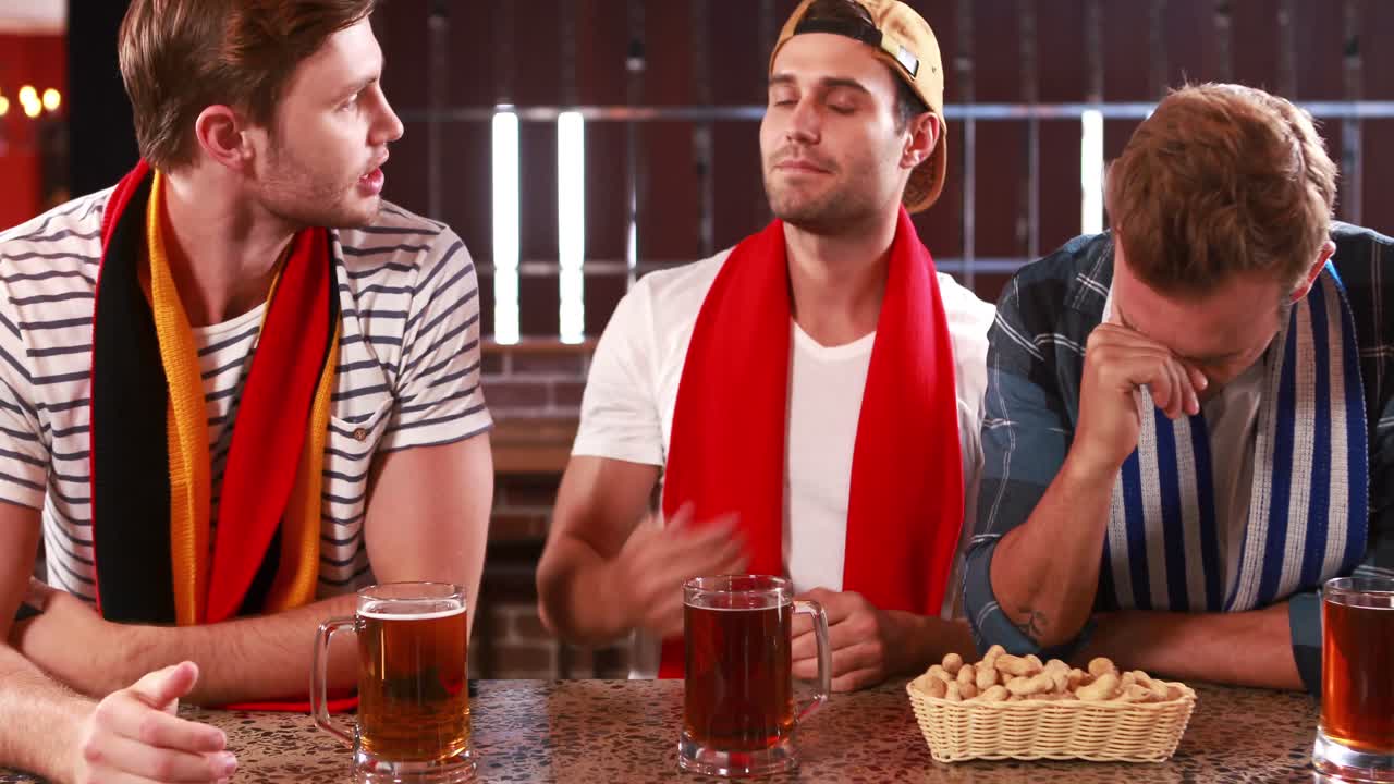 실망한 잘생긴 친구들이 스포츠를 보고 있습니다.