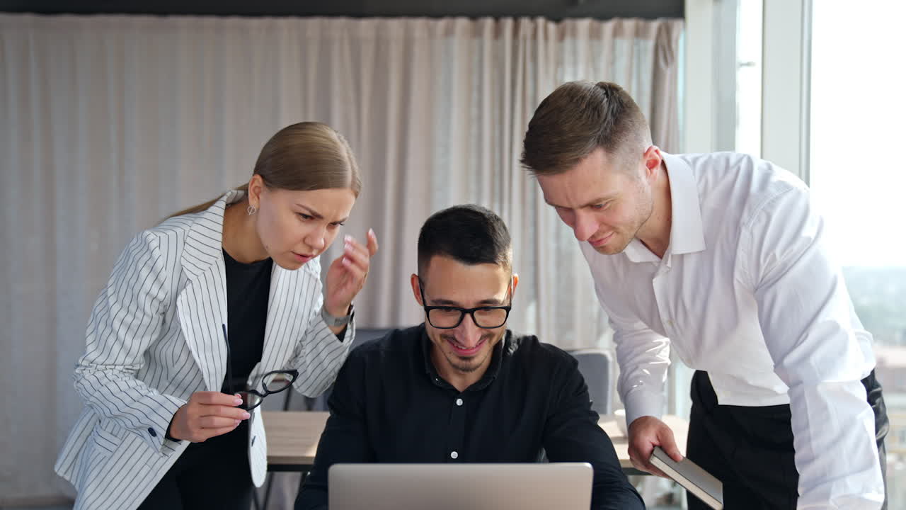 Colleagues solving task cooperating at work. Three diverse employees look at one laptop screen discussing a problem, being positive.