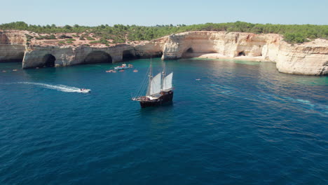 fantastic aerial view of the coast of the town of benagil and a wonderful sailboat