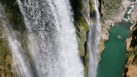 vista aérea gran dron de la cascada de tamul se inclina hacia abajo para mostrar el agua cayendo con el arco iris en san luis potosí méxico