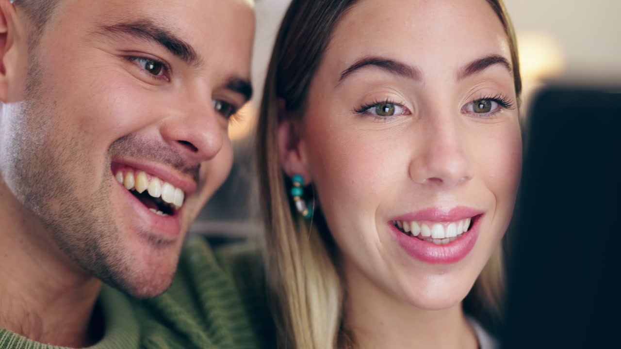 pareja feliz, abrazar y relajarse en el sofá con la tableta