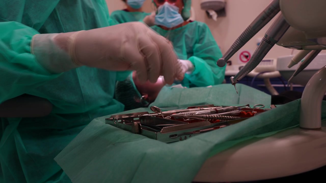 Dentist hesitates choosing tools for surgery. Close up, slow motion, detailed shot