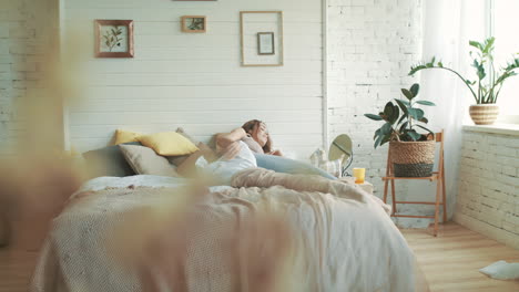 uma mulher grávida feliz a levantar-se no quarto, a mãe a acariciar a barriga em casa.