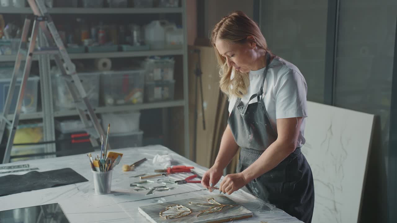 Woman Artist Working on a Mixed Media Painting in her Studio