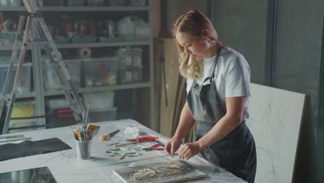 woman artist working on a mixed media painting in her studio