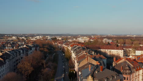 Vista-Aérea-Del-Barrio-De-La-Ciudad.-Drone-Siguiendo-Calle-Ancha.-Hora-Dorada.-Fráncfort-Del-Meno,-Alemania