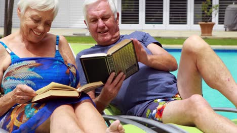 senior couple reading books on lounge chair