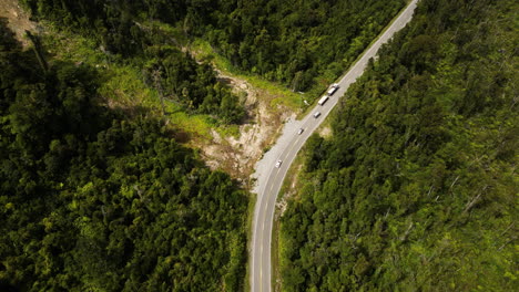 Cars-driving-on-curvy-road-of-New-Zealand,-aerial-drone-view