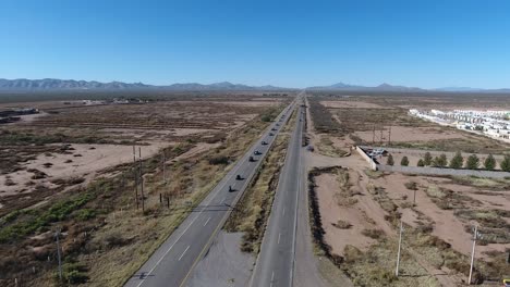 Línea-De-Disparos-De-Drones-De-Vehículos-De-Servicio-De-Emergencia-En-Una-Carretera-Del-Desierto