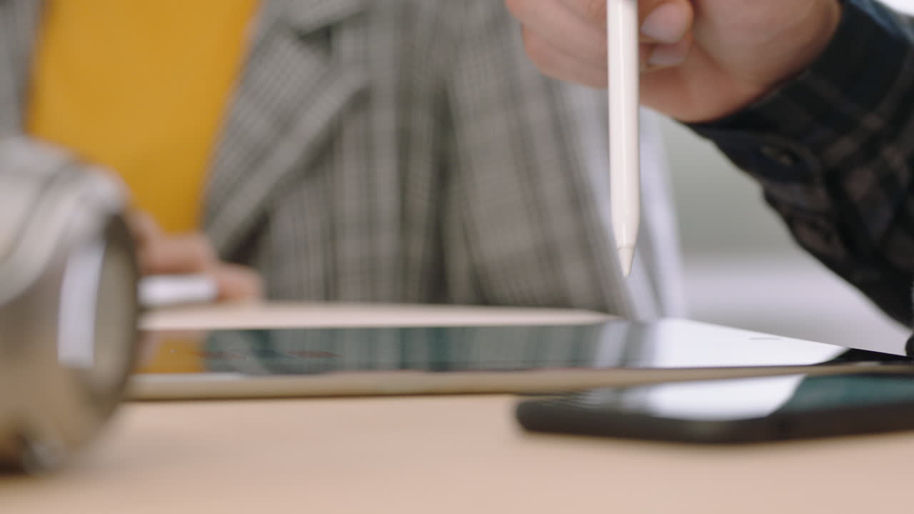 close up hands businessman using digital tablet computer showing business woman information poitnting stylus pen at screen on mobile touchscreen device