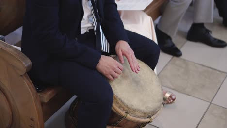 close-up of man playing drum in ceremony at catholic church