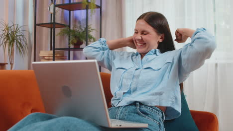 surprised happy young woman using laptop computer receive good news email message at home room