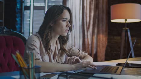 mujer de negocios centrada trabajando en la computadora portátil por la noche. especialista en negocios