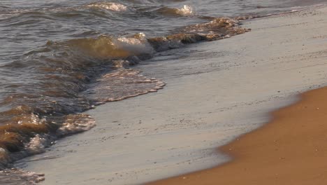 Meereswellen-Am-Sandstrand,-Nahaufnahme-Der-Küste-In-Zeitlupe