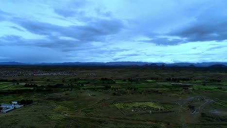 imagen aérea de un pequeño pueblo en una zona rural en el fondo de la cordillera de la distancia