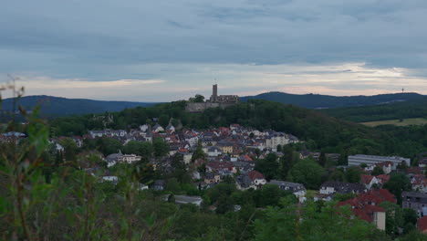 Eine-Burgruine-Auf-Einem-Hügel-Mit-Einem-Dorf-Im-Vordergrund