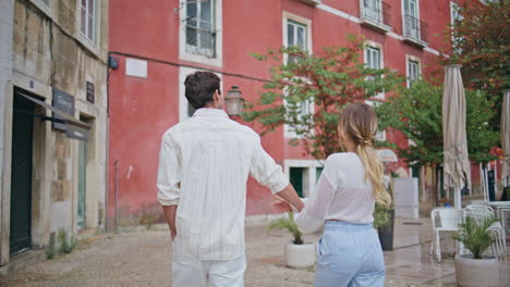 happy lovers looking town architecture at romantic walk back view. loving couple