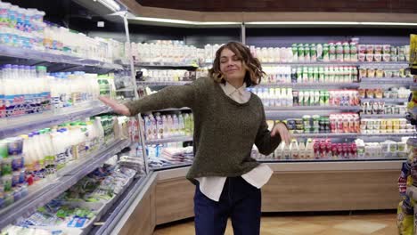 Mujer-Joven-Bailando-A-Través-De-Los-Pasillos-De-La-Tienda-De-Comestibles