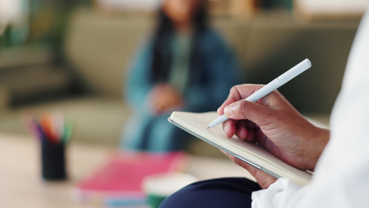 Therapist taking notes during a session with a patient